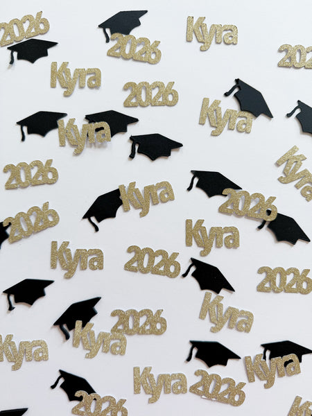 Gold glitter Class of 2026 graduation confetti with custom name Kyra and black cap accents